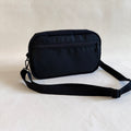 Black crossbody bag on a light gray background