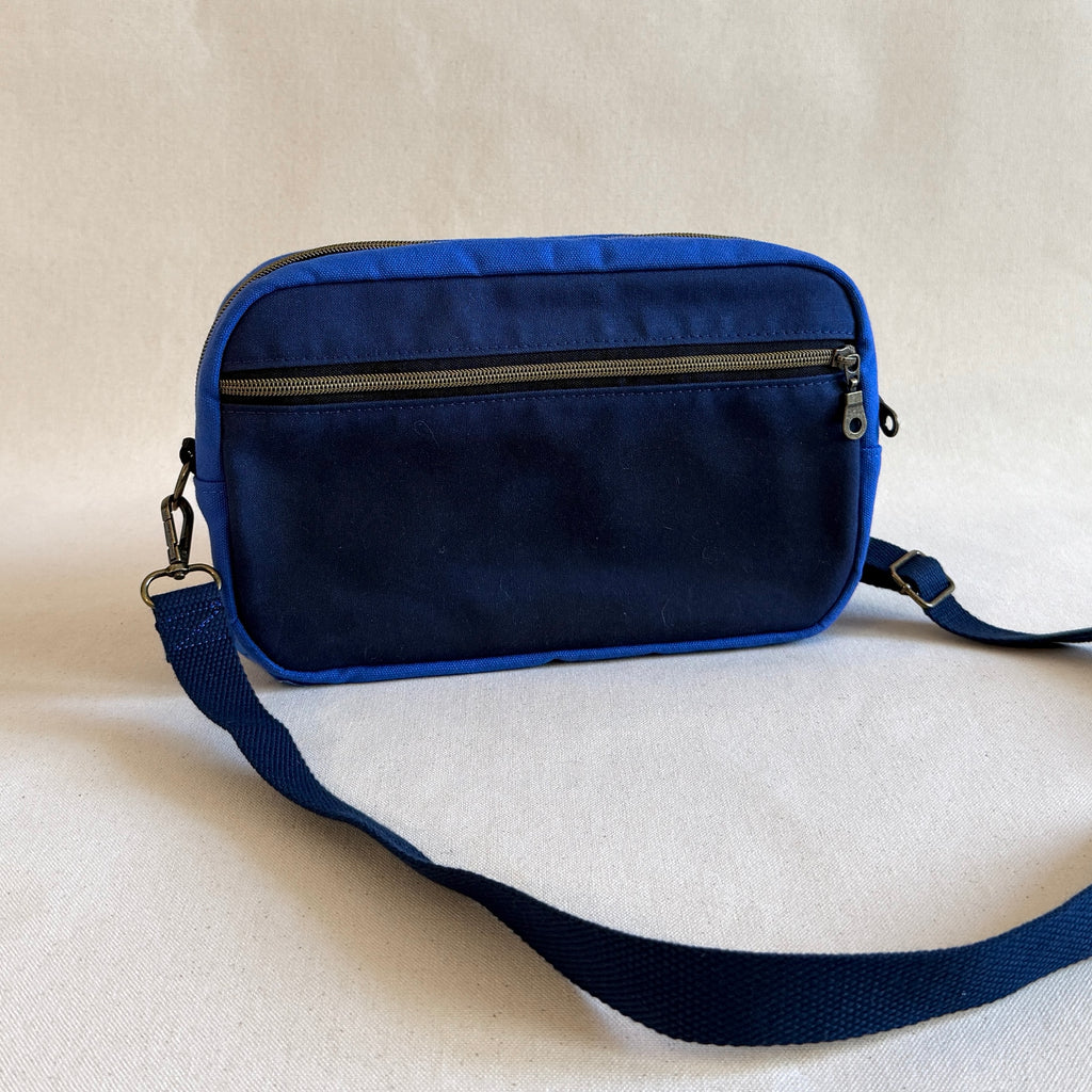 Blue bag with a strap on a beige background