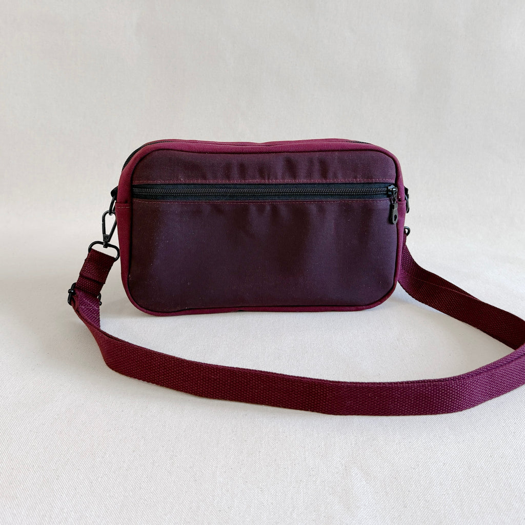 Deep red crossbody bag on a light gray background
