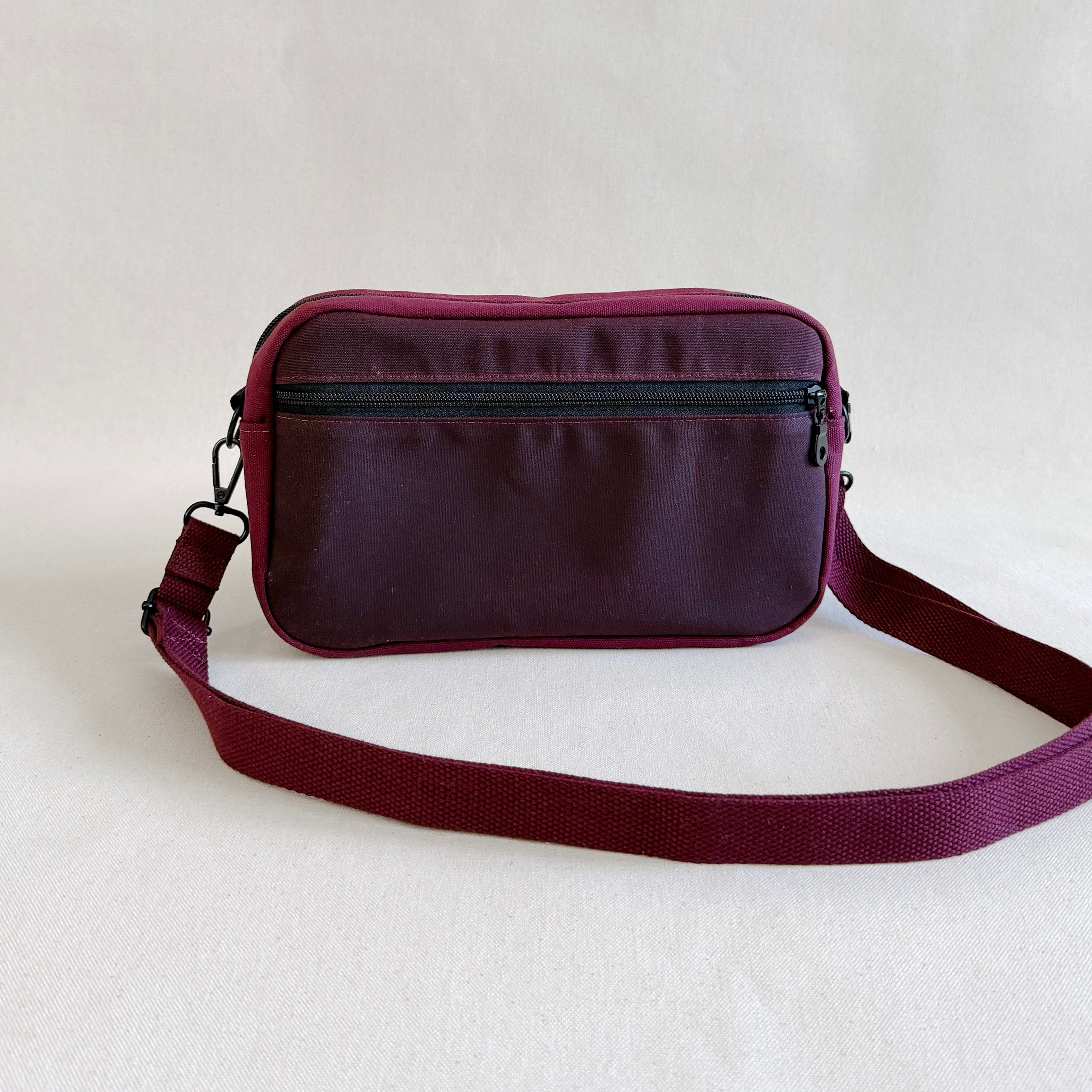 Deep red crossbody bag on a light gray background
